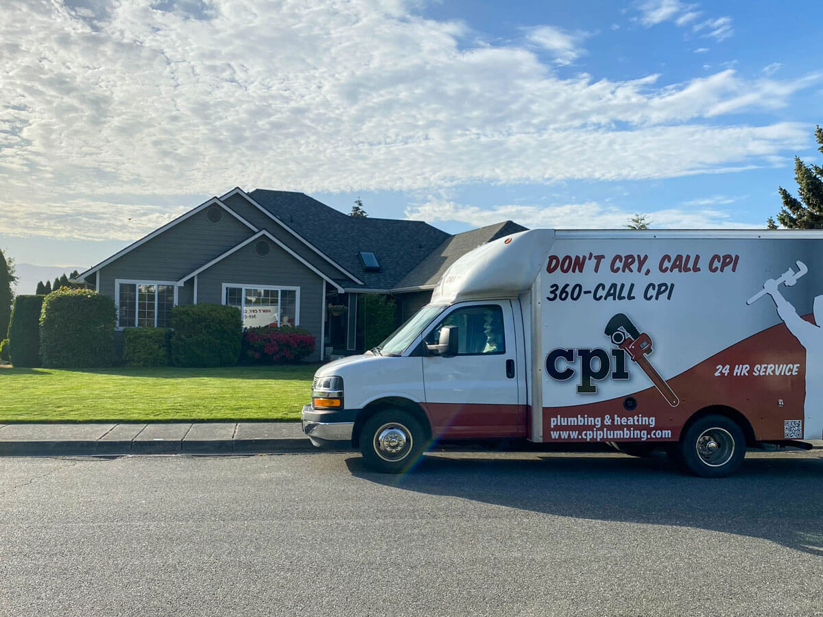 White and burgundy CPI plumbing and heating service van parked in front of a residential home with landscaping.